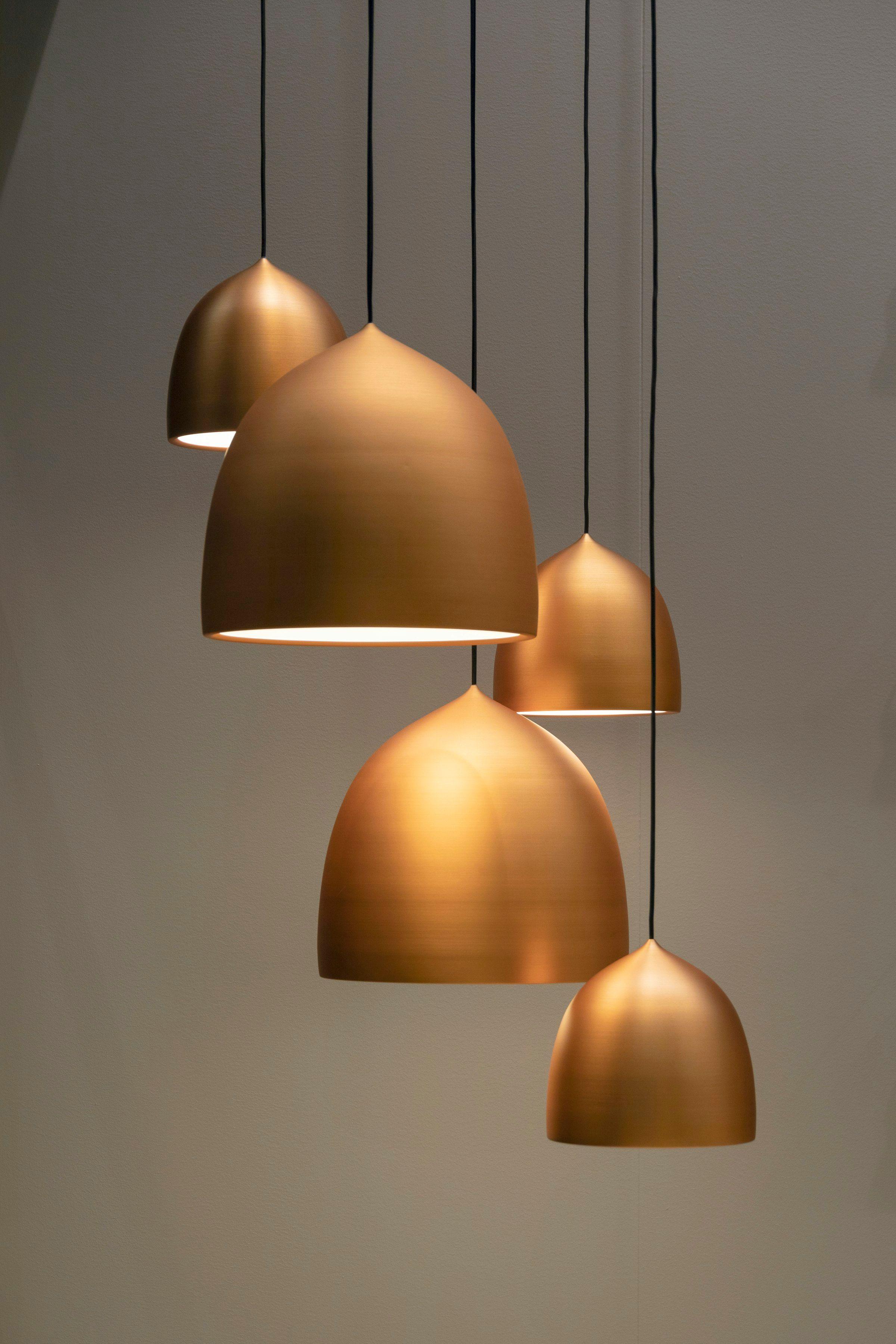 Row of brass pendant lamps hanging above a work surface