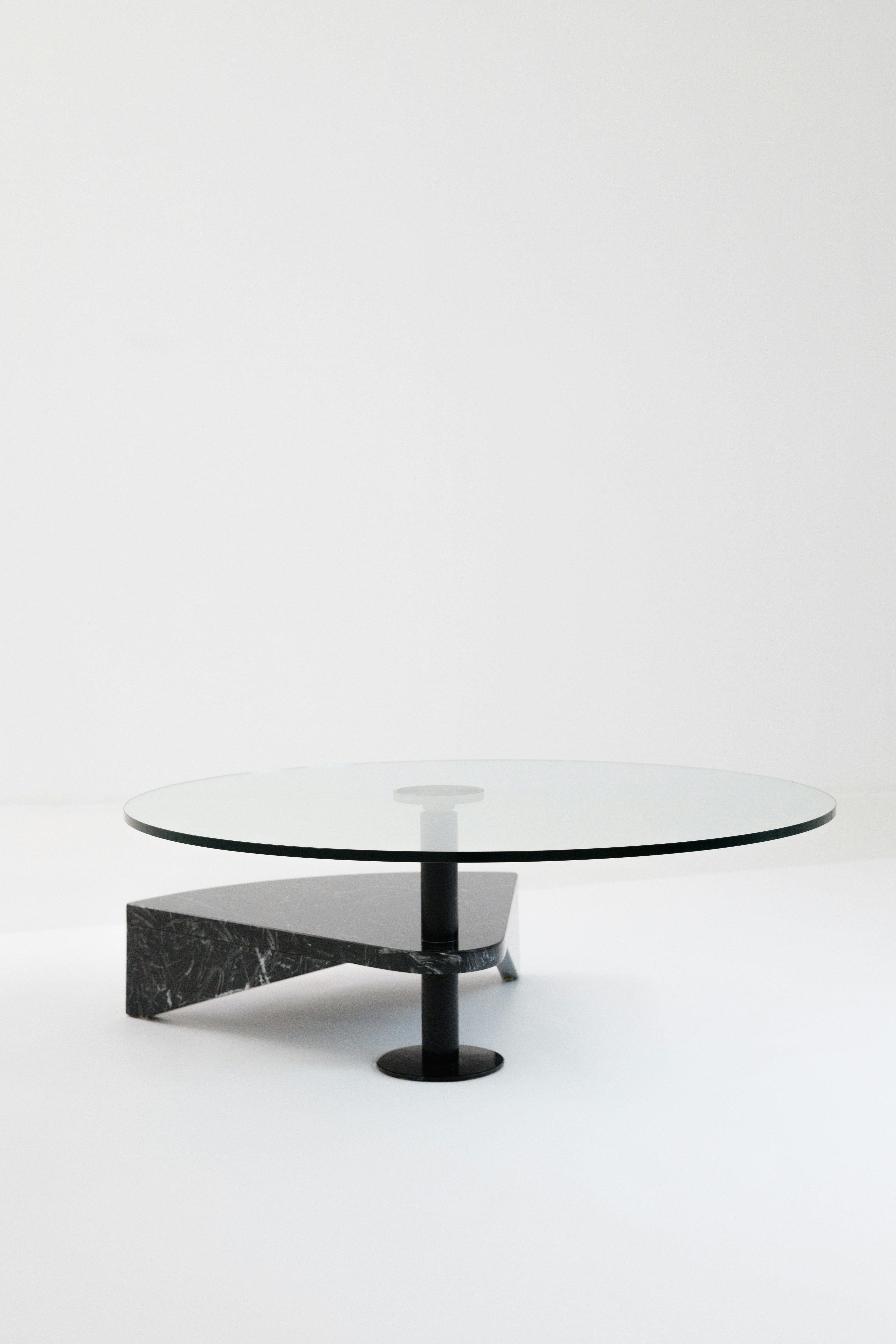 Low glass coffee table on a stone and steel base